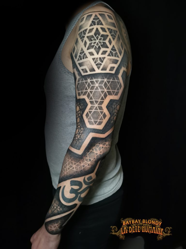 Baybay Blondy, tatoueuse guest à Paris - Bras géométrique ponctué d’un om tatoué par son confrère Bro Vanthorn