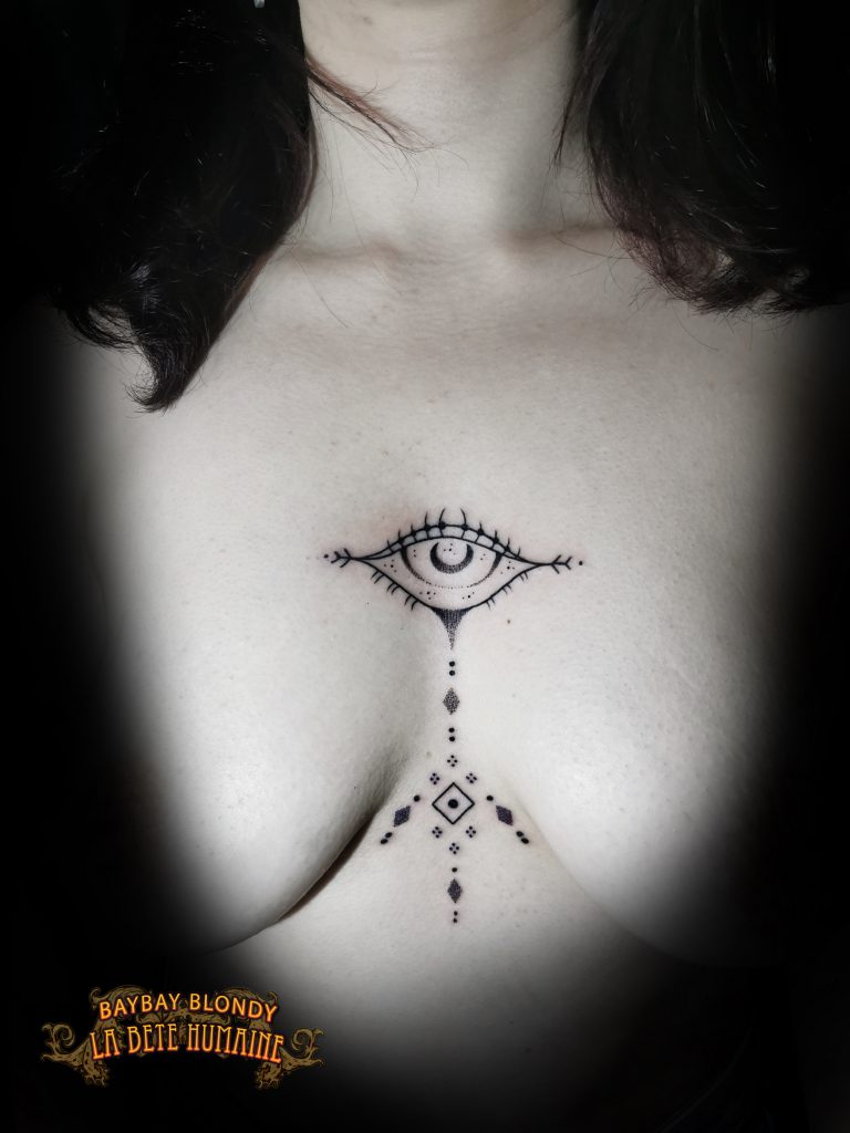 Baybay Blondy, tatoueuse guest à Paris - Œil géométrique tatoué entre les seins par Baybay Blondy