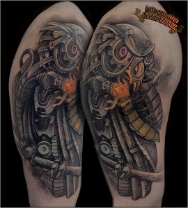 Hibou mécanique tatoué en couleurs sur l’épaule par Pierre-Gilles Romieu