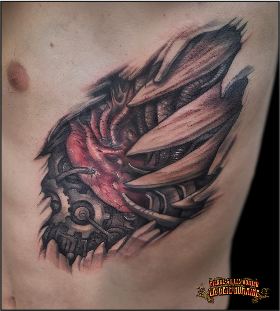 Tatouage de cœur biomécanique réalisé en couleurs par Pierre-Gilles Romieu