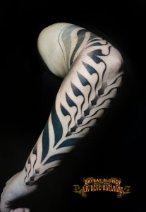Colonne stylisée tatouée sur l’avant-bras par Baybay Blondy