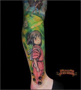 Portrait de Chihiro intégré dans une composition autour du studio Ghibli tatouée par Pierre-Gilles Romieu