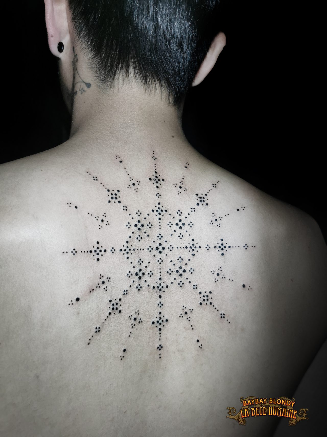 Tatouage dorsal de gouvernail stylisé réalisé par Baybay Blondy