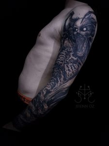 Tatouage dark sur tout le bras réalisé par Jhenn Oz