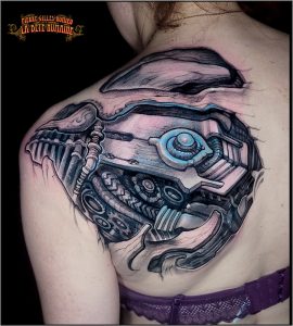 Tattoo biomécanique aux reflets bleus réalisé sur l’omoplate par Pierre-Gilles Romieu