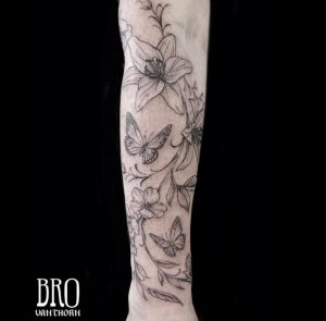 Tatouage de papillons et fleurs minimalistes et lignes fines réalisé par Bro à La Bête Humaine Tatouage à Paris