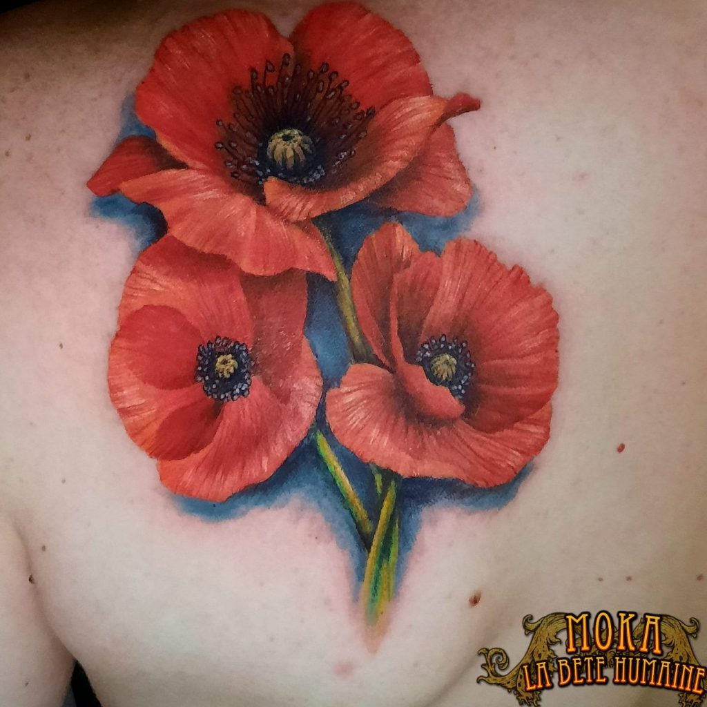 Realistic tattoo of three red poppies on the upper back