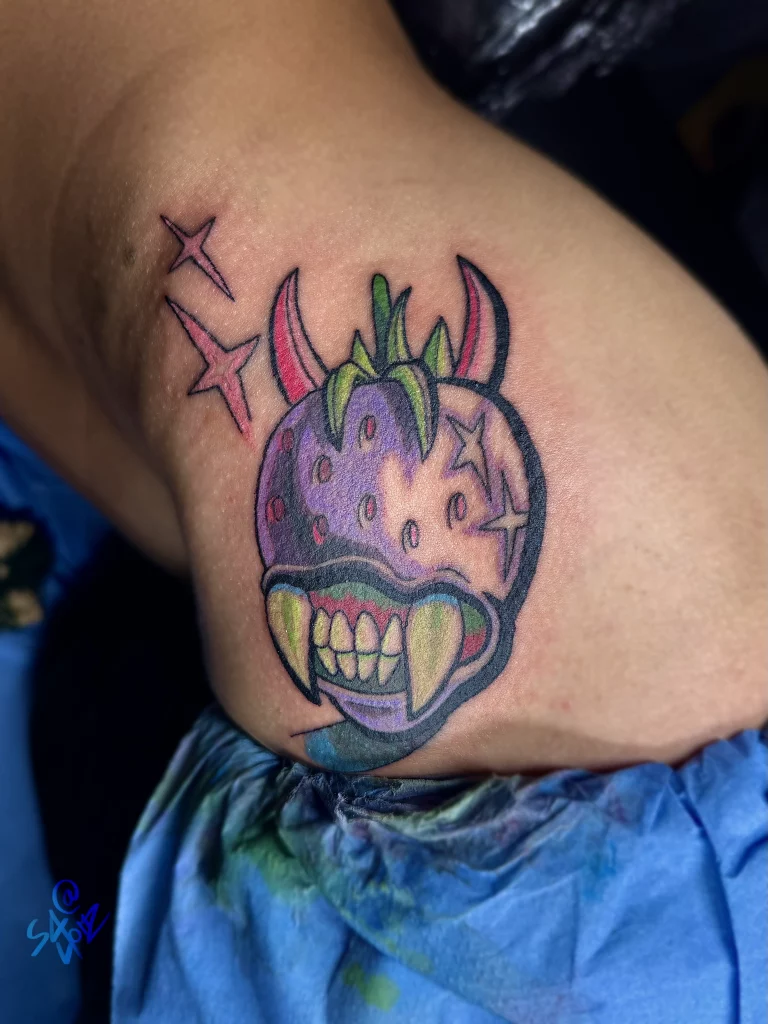 Tatouage d'une fraise en couleur réalisé par Salomé - La Bête Humaine Paris