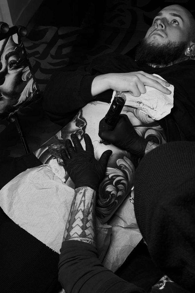 Moka working on a realism stomach tattoo during a tattoo session in a Paris tattoo studio.