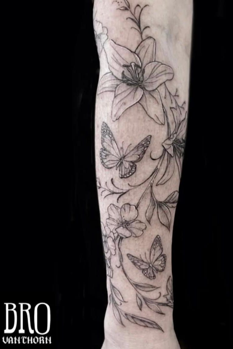 Tatouage de papillons et fleurs minimalistes et lignes fines réalisé par Bro à La Bête Humaine Tatouage à Paris