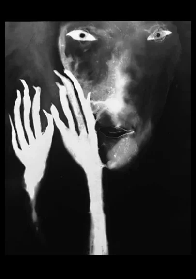 Autoportrait en noir et blanc d’Ai Huang, visage sombre accompagné de deux mains blanches aux doigts allongés, série KABRALA.