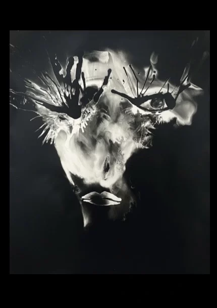 Autoportrait en noir et blanc d’Ai Huang, visage partiellement dissous où les yeux et la bouche émergent parmi des traces chimiques, série KABRALA.
